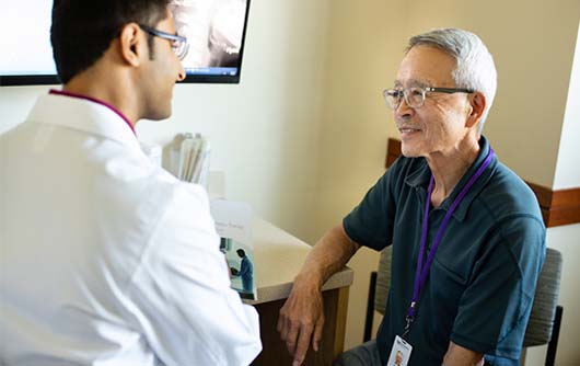 A male physician meeting with an elderly male patient.
