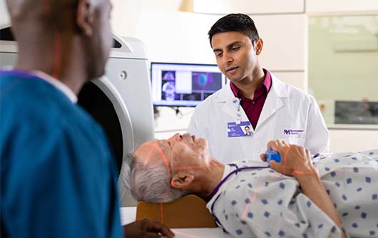 A proton therapy physician talking to a patient before treatment.