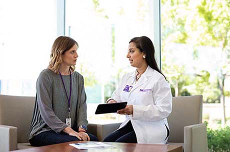 A female proton therapy physician discussing proton therapy with a young woman.